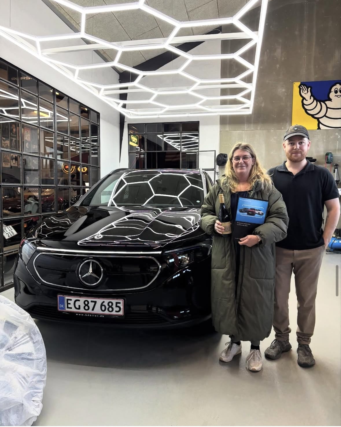 To personer står foran sort Mercedes i showroom