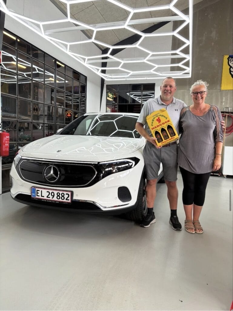 Par står foran hvid Mercedes i bilforretning