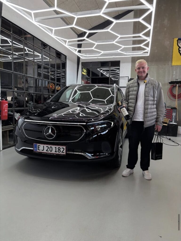 Mand står ved sort Mercedes i bilforretning